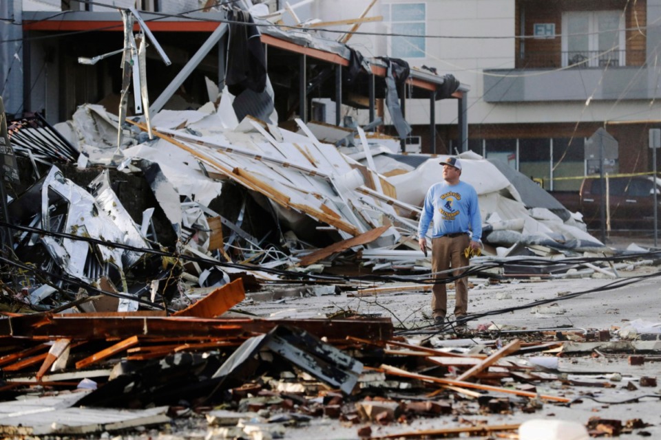 <strong>A man looks over buildings destroyed by storms Tuesday, March 3, 2020, in Nashville, Tennessee. Tornadoes ripped across Tennessee early Tuesday, shredding buildings and killing multiple people.</strong> (AP Photo/Mark Humphrey)