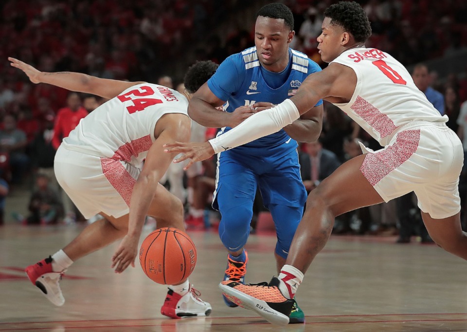 <strong>University of Memphis guard Alex Lomax (center) makes a drive under pressure by Houston's Marcus Sasser (0) and Quentin Grimes (24) during the Tigers' game against the Cougars at the Fertitta Center in Houston on March 8, 2020.</strong> (Jim Weber/Daily Memphian)