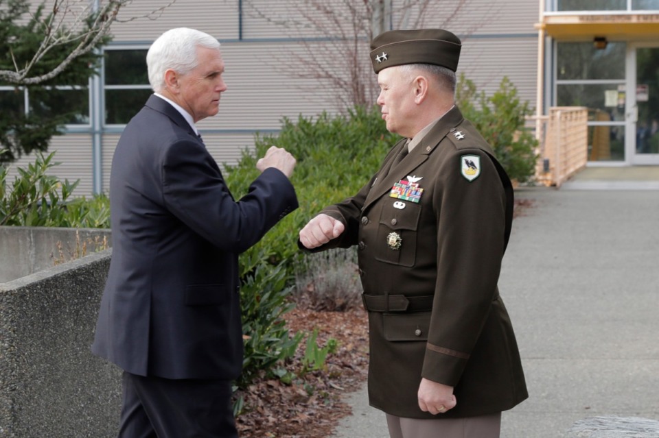 <strong>Vice President Mike Pence bumps elbows with Maj. Gen. Bret Daugherty, Adjutant General of Washington State, before a tour of the Washington State Emergency Operations Center, Thursday, March 5, 2020 at Camp Murray in Washington state to discuss the COVID-19 coronavirus. Officials are avoiding shaking hands as a precaution against the virus.</strong> (AP Photo/Ted S. Warren)