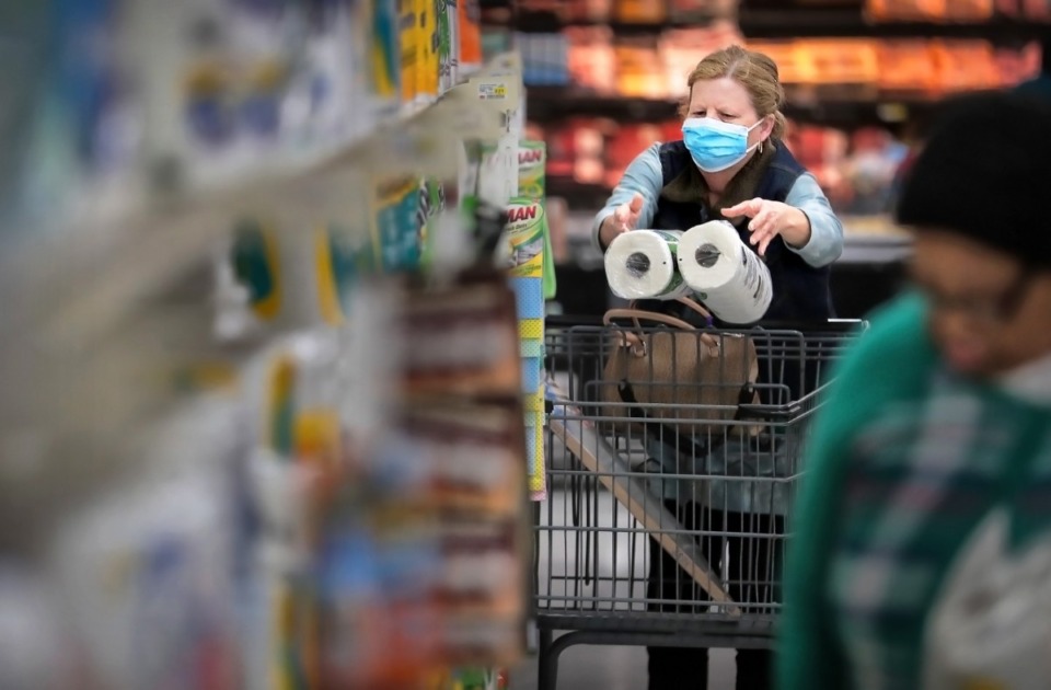 <strong>Deeanna Beene shops for paper goods during a busy day at the CashSaver in Midtown on March, 12, 2020 where there were some shortages on cleaning wipes and disinfectant as customers fearful of COVID-19 try to stock up. Beene says her doctor suggested she wear a mask because she might be at an elevated risk due to her age and diabetes.</strong> (Jim Weber/Daily Memphian)