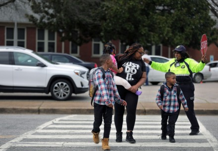<strong>Westside Elementary School parent Jacquetta Surney (center) crosses the street after picking her children Dominic McCoy, Damarrhi McCoy and Meilani Surney from school on March 12, 2020.</strong> (Patrick Lantrip/Daily Memphian)