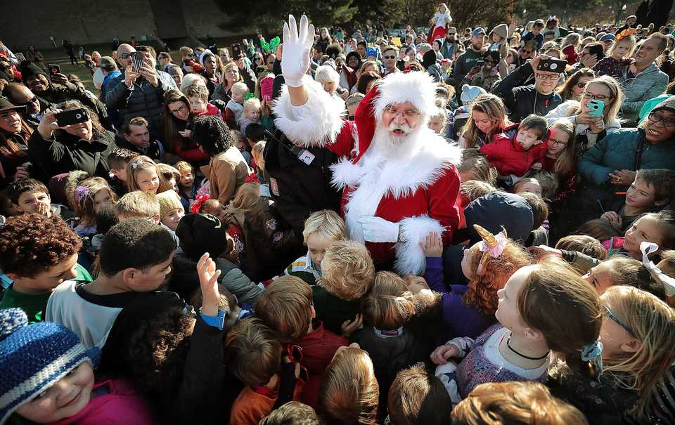 <strong>Families crowd around Santa, played by Charles Bohannon, as he arrives by helicopter at the Pink Palace Museum on Saturday, Nov. 17, to officially open the Enchanted Forest Festival of Trees, a fundraiser for Le Bonheur Children's Hospital.</strong> (Jim Weber/Daily Memphian)