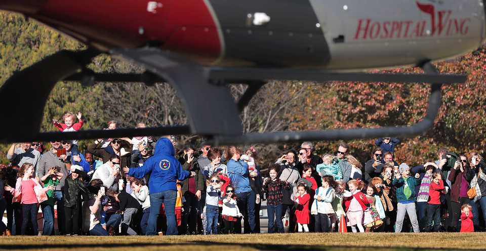 <strong>An excited crowd of kids and parents huddle under a sudden blast of wind off the rotors as Santa arrives by helicopter at the Pink Palace Museum on Saturday, Nov. 17, to officially open the Enchanted Forest Festival of Trees, a fundraiser for Le Bonheur Children&rsquo;s Hospital.</strong> (Jim Weber/Daily Memphian)