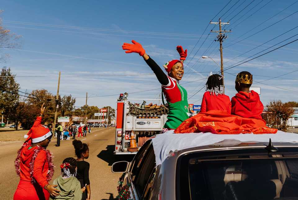 <strong>Kimberly Peoples (center) celebrates as she cruises down Elvis Presley Boulevard during the Whitehaven Christmas Parade on Saturday, Nov. 17. The parade is in its 21st year and drew over 4,000 attendees. Just under 200 schools, nonprofits and other organizations participated in the 2018 parade, one of several outreach initiatives held by the Academy for Youth Empowerment.</strong> (Houston Cofield/Daily Memphian)