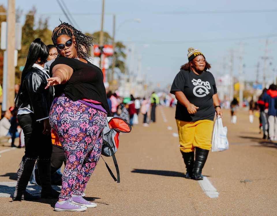 <strong>Tejuana Boddie (left) dances in the middle of Elvis Presley Boulevard as a high school band plays during the Whitehaven Christmas Parade on Saturday, Nov. 17. The parade is in its 21st year and drew over 4,000 attendees. Just under 200 schools, nonprofits and other organizations participated in the 2018 parade, one of several outreach initiatives held by the Academy for Youth Empowerment.</strong> (Houston Cofield/Daily Memphian)