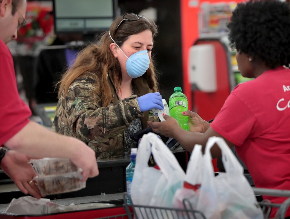 <strong>Crystal Dannell picks up a few snacks during a busy day at the CashSaver in Midtown on March, 12, 2020 where there were some shortages on cleaning wipes and disinfectant as customers fearful of COVID-19 try to stock up. Dannell has been visiting her brother, who suffers from leukemia, at the hospital and was asked to take extra precautions while out.</strong> (Jim Weber/Daily Memphian)