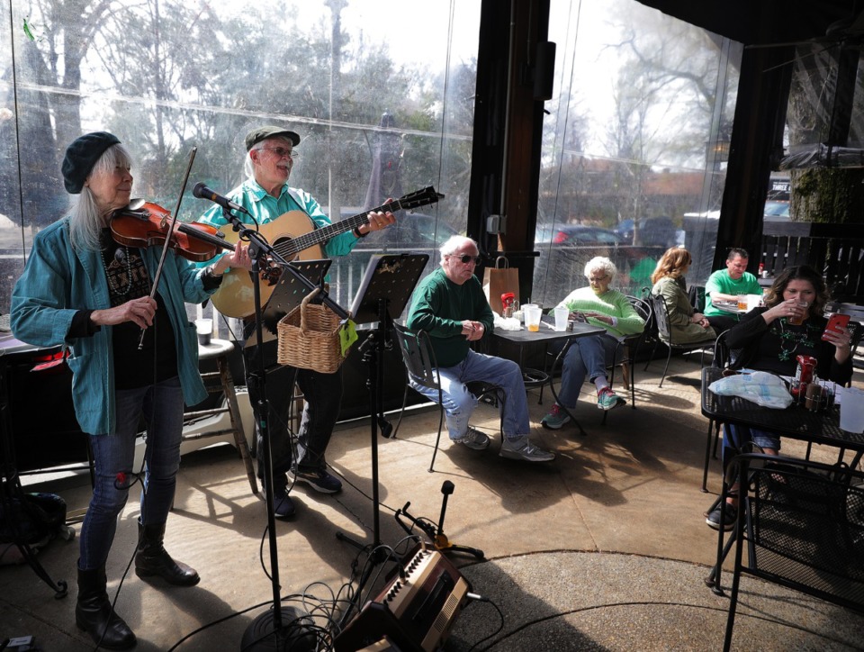 <strong>And the band plays on ... Larkin Bryant (left) and Jim Turpin turn out traditional Irish tunes at Celtic Crossing on St. Patrick's Day March 17, 2020, as pub-goers try to balance everyday life with social distancing in wake on the coronavirus pandemic.</strong> (Patrick Lantrip/Daily Memphian)