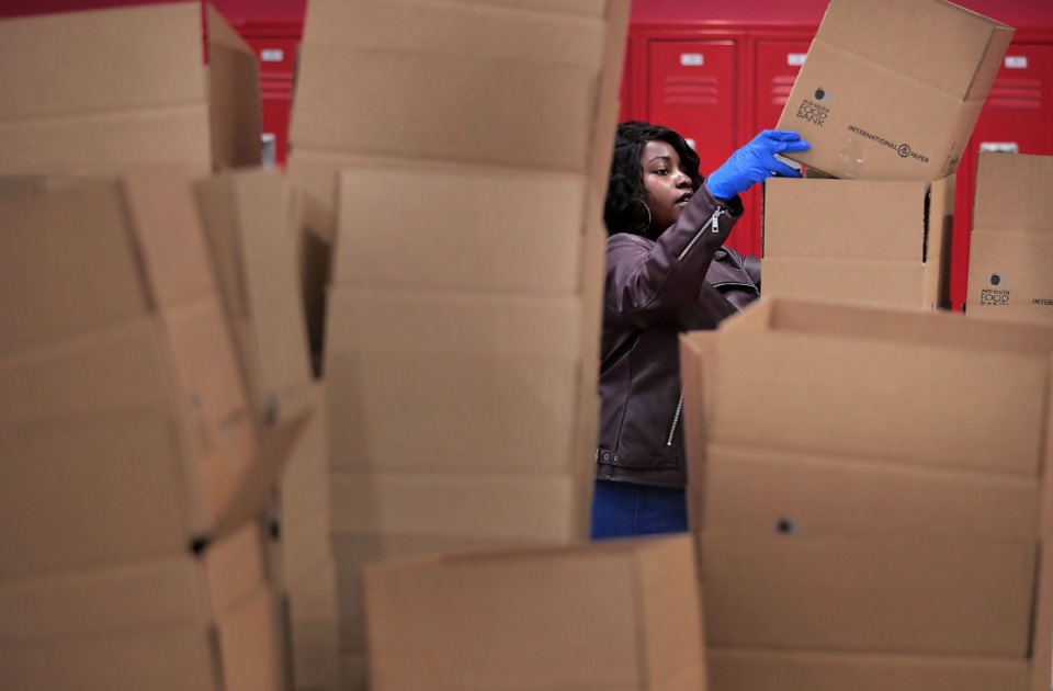 <strong>Ariel Wade assembles boxes as volunteers gather in groups of 10 to work an assembly line on March 17, 2020, at the Midsouth Food Bank warehouse putting together 14-day food kids for needy families in Memphis.</strong>&nbsp;<strong>The Food Bank is trying to assemble 50,000 kits consisting of 25 pounds of canned, vegetables, canned fruit, peanut butter, oatmeal and rice to feed families that may be forced into isolation by COVID-19.&nbsp;</strong>(Jim Weber/Daily Memphian)