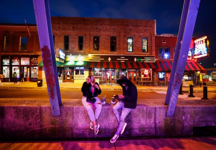 <strong>Kendrica Wright and Lee Williams sit on an empty Beale Street on St. Patrick&rsquo;s Day Tuesday, March 17, 2020. Area restaurants and bars are experiencing smaller number of customers due to the outbreak of coronavirus.</strong> (Mark Weber/Daily Memphian)