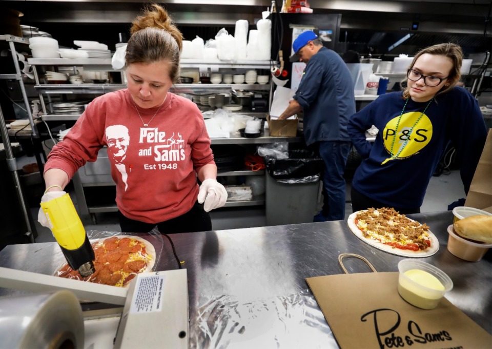 <strong>Pete &amp; Sam&rsquo;s Italian Restaurant&rsquo;s Jennifer Sing (left) and Mia Bomerito (right) shrink wrap pizzas that will be frozen and used for delivery or pickup orders on on March 17, 2020. The restaurant is shifting to producing more pre-made items that will be used for delivered and pickup orders, in the wake off social distancing due to the threat of the coronavirus.</strong> (Mark Weber/Daily Memphian)