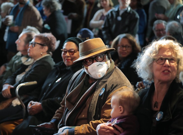 <strong>Concerned about catching "A cold or coronavirus, or just getting sick," Ernest Trice dons a mask in a crowd of Bloomberg supporters at Minglewood Hall as Democratic presidential contender Michael Bloomberg delivers his stump speech during a campaign stop in Memphis on Feb. 28, 2020.</strong> (Jim Weber/Daily Memphian)