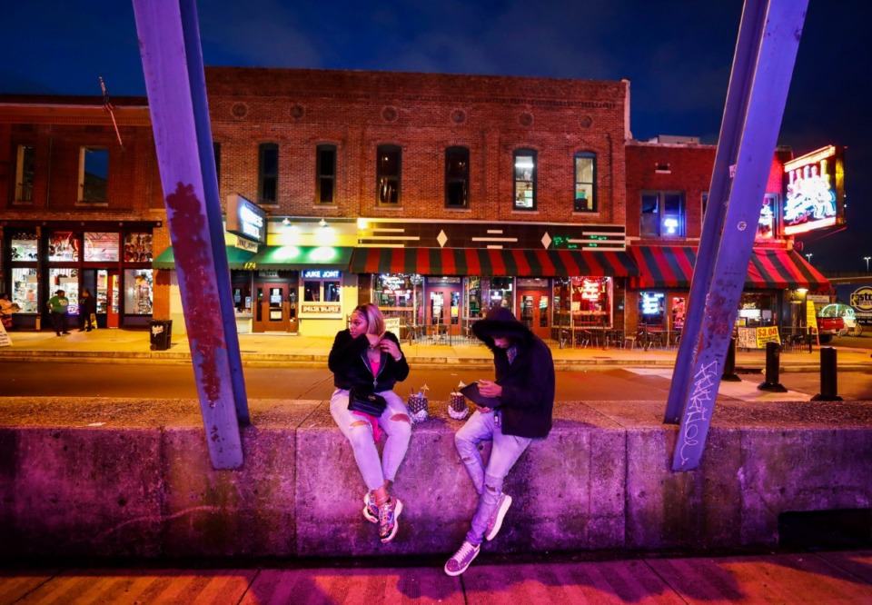 <strong>Kendrica Wright and Lee Williams sit on an empty Beale Street on St. Patrick's</strong><strong> Day on Tuesday, March 17, 2020. Area restaurants and bars are experiencing a smaller number of customers due to the outbreak of coronavirus.</strong> (Mark Weber/Daily Memphian)