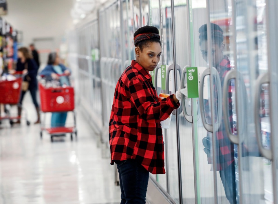 <strong>Shanetha Russell wipes down refrigerator doors with cleaning wipes at the Target Memphis Central Store on Wednesday, March 18, 2020.</strong> (Mark Weber/Daily Memphian)