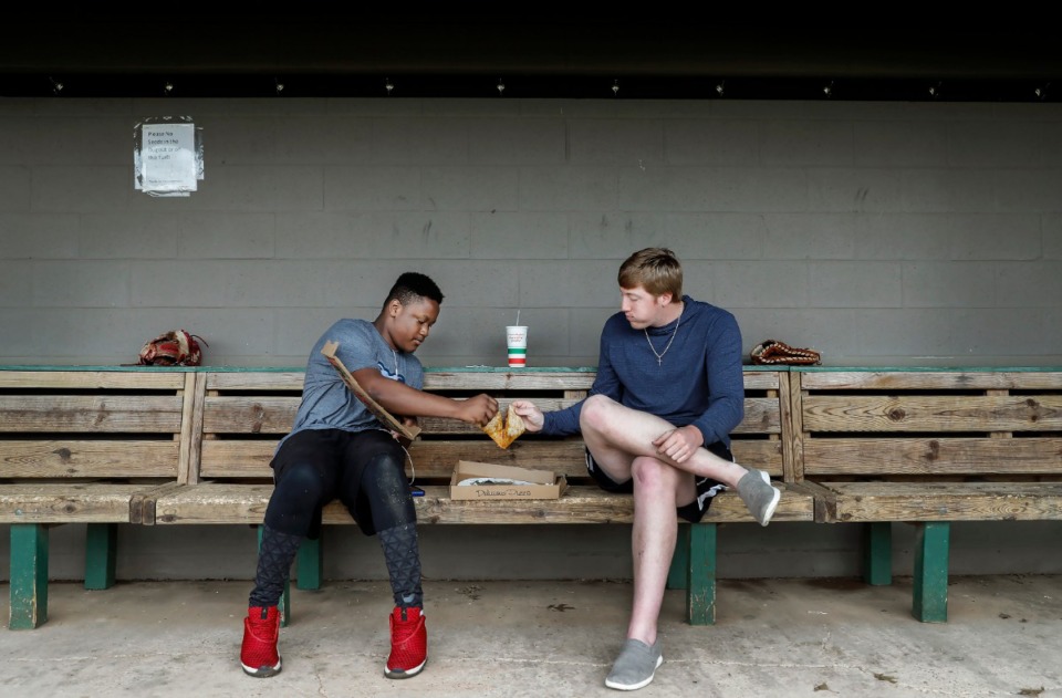 <strong>Rhodes College senior pitcher Trey Sledge (right) shares a pizza with his &ldquo;little brother&rdquo; Edward Cathey, 15, inside the dugout at Irwin Lainoff Stadium on March 19, 2020. Sledge came back to school as a fifth-year senior to play baseball rather than attend medical school. Then his last season, one of Rhodes' best, was cut short by the coronavirus outbreak.</strong> (Mark Weber/Daily Memphian)