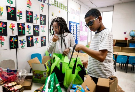 <strong>Kalynn Allen, 10, (left) ponders which donated supplies to grab while filling bags on Friday, March 20, with Vincent Martin, 12, that will be given to parents at KIPP Memphis Preparatory Elementary school.</strong> (Mark Weber/Daily Memphian)