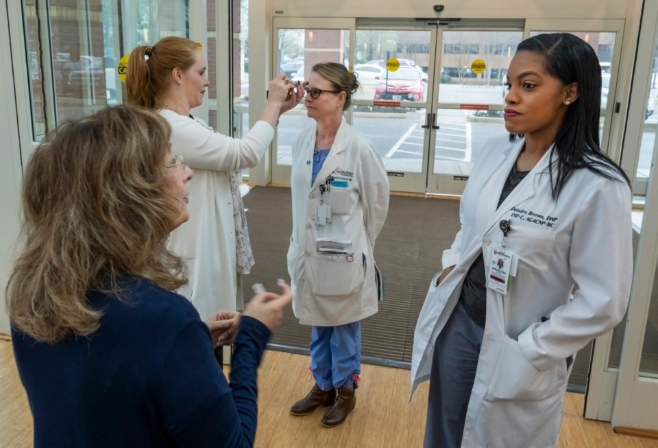 <strong>Rita Neely interviews Deiadra Brown, DNP, while Anna Lopez scans the forehead of Dr. Maureen Smithers as they enter Methodist-LeBonheur Germantown Thursday, March 19, 2020.&nbsp;</strong> (Greg Campbell/Special to The Daily Memphian)