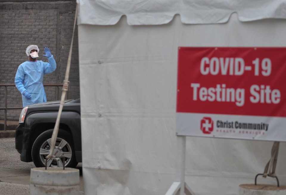 <strong>Will Jackson directs traffic as staff from Christ Community Health Services administer some 50 free COVID-19 tests at a drive-thru tent behind their South Memphis clinic on March 21, 2020. Patients were screened before they could be tested to determine if they had symptoms associated with COVID-19, whether they'd traveled to an at-risk area or had otherwise been exposed to the coronavirus.</strong> (Jim Weber/Daily Memphian)