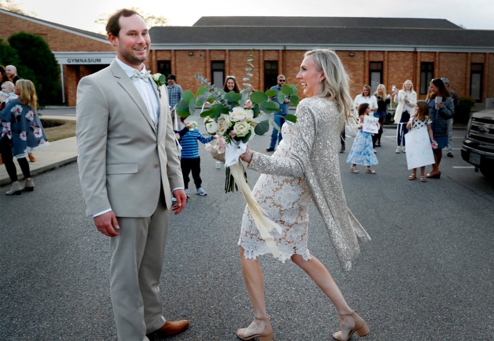 <strong>Newlyweds John Steinert and Holly Whittle celebrate with cheering friends who surprised them in the parking lot after their wedding on Saturday, March 21, 2020, at St. Louis Catholic Church.</strong> (Mark Weber/Daily Memphian)