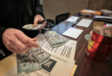 <strong>Josh Spickler of Just City counts out money to post five bonds on March 22, 2020. Spickler plans to bail a series of inmates from the county jail to help them escape the threat of possible COVID-19 infection.</strong>&nbsp; (Jim Weber/Daily Memphian)