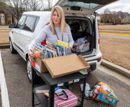 <strong>Bailey Station Elementary School librarian Jennifer Boren takes home stacks of books from the school for virtual story time with the students of the school. The teachers and administration of the school gathered for a caravan through the neighborhoods of their students Monday, March 23, 2020.</strong> (Greg Campbell/Special to The Daily Memphian)