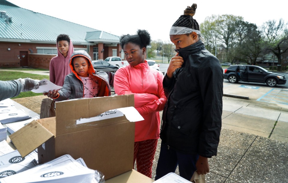 <strong>Students (from left) Traevone Toney, 12; Zaniya Toney, 8; Janae Fisher, 10, and Kelsey Porter, 12, pick up instructional learning packets during a Shelby County Schools food distribution event Monday, March 23, at Orange Mound Community Center. On Monday,&nbsp;</strong><span><strong>the YMCA began running 62 meal-distribution sites across Shelby County.</strong>&nbsp;</span>(Mark Weber/Daily Memphian)