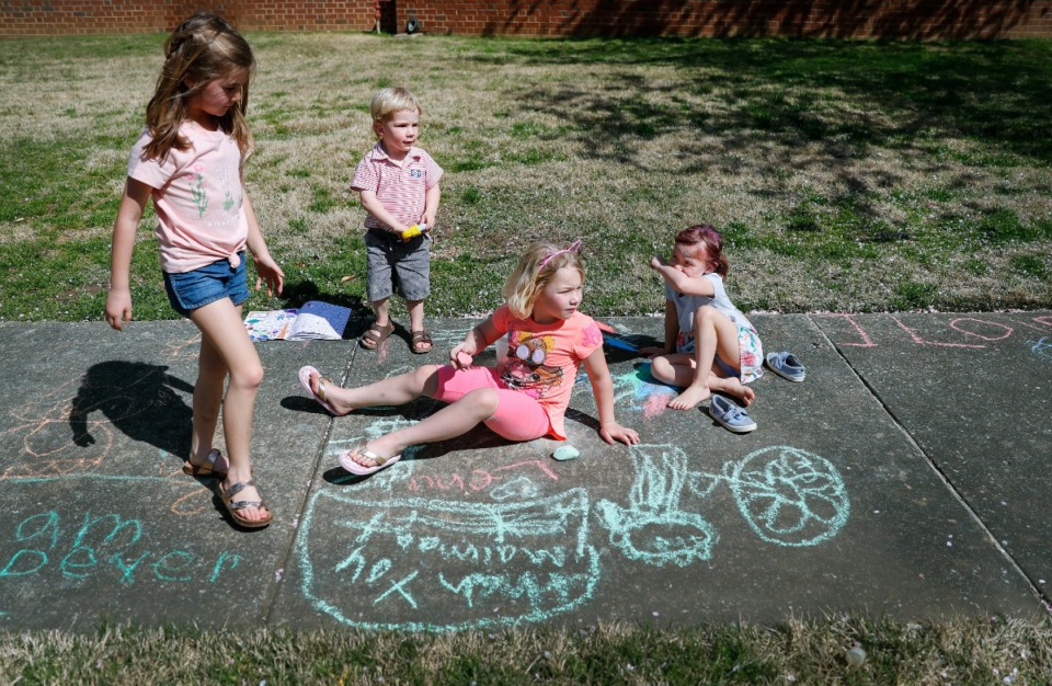 <strong>Neighborhood friends (let to right) Elliana Mohundro, 7, Lewis Koelsch, 3, Lena Koelsch, 6, and Naomi Burton, 4, draw encouraging messages to the sanitation workers and others walking along their street on Thursday, March 26, in East Memphis.</strong> (Mark Weber/Daily Memphian)