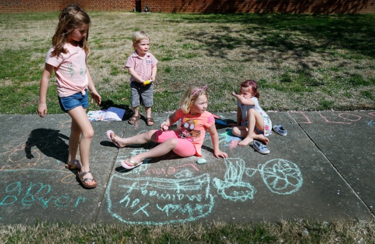 <strong>Neighborhood friends (let to right) Elliana Mohundro, 7, Lewis Koelsch, 3, Lena Koelsch, 6, and Namoi Burton, 4, draw encouraging messages to the sanitation workers and others walking along their street on Thursday, March 26, 2020 in East Memphis.</strong> (Mark Weber/Daily Memphian)