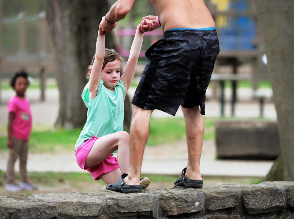 <strong>Renzo Gabaldon (right) pulls his niece Hope Jacobs, 7, out of the Overton Park playground after he noticed her inside the wall, but some Memphians chose to ignore a posted warning on Friday, March 27, 2020, which is one of the reasons why city officials have threatened to shutter parks entirely.</strong> (Jim Weber/Daily Memphian)