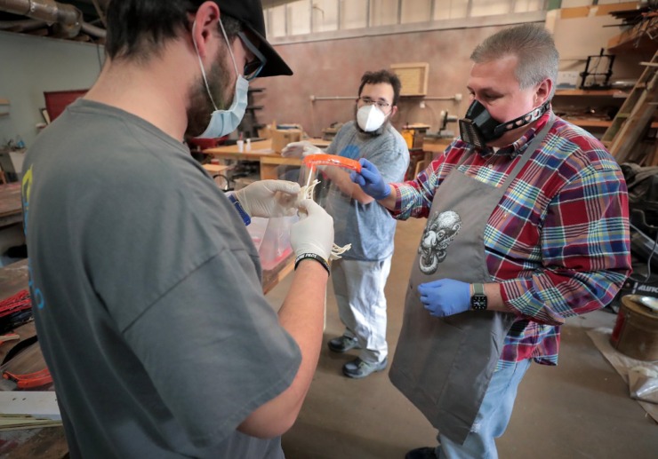 <strong>Dave Myers (left), Ernest McCracken and Rich Thompson (right) with the Midsouth Makers donate their time to assemble face shields for the Memphis Medical Society on March 29, 2020. The group of tinkerers used 3-D printers to create the frame and a laser cutter to make a matching transparent shield.</strong> (Jim Weber/Daily Memphian)