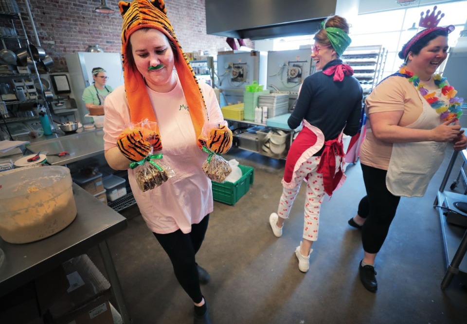 <strong>Jordan Badgett (from left), Kat Gordon and Bridget Carratt joke around in the kitchen as Muddy's Bake Shop staff bake their way through the remainder of their supplies during a big temporarily-closing, April Fools' Day sale and costume party all rolled into one at Muddy's on Broad Avenue on Wednesday, April 1.</strong> (Jim Weber/Daily Memphian)