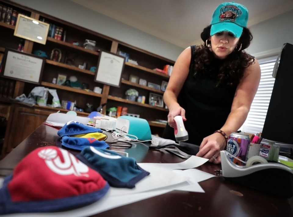 <strong>Rebecca Fava applies a logo to one of the cloth masks she has been decorating with Memphis themes and selling in her Southaven home office on April 3, 2020. Fava says she has a backlog of 50 masks, but has a shipment coming in from California to be adorned.</strong> (Jim Weber/Daily Memphian)