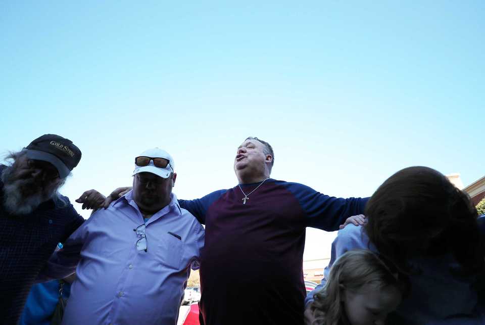 <strong>Randy Dickey, 61, (center) says a prayer outside Napa Cafe before participating in the restaurant's free annual Thanksgiving meal.</strong> (Houston Cofield/Daily Memphian)
