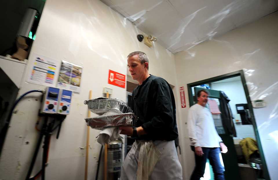 <strong>Scott Delarme, a volunteer chef at Napa Cafe, carries trays of food that will feed guests at the restaurant's annual free Thanksgiving meal.</strong>&nbsp;(Houston Cofield/Daily Memphian)