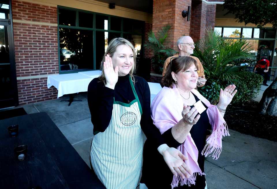 <strong>Glenda Hastings (left), owner of Napa Cafe, sings songs with a line of homeless visitors before kicking off their free annual Thanksgiving meal.</strong> (Houston Cofield/Daily Memphian)