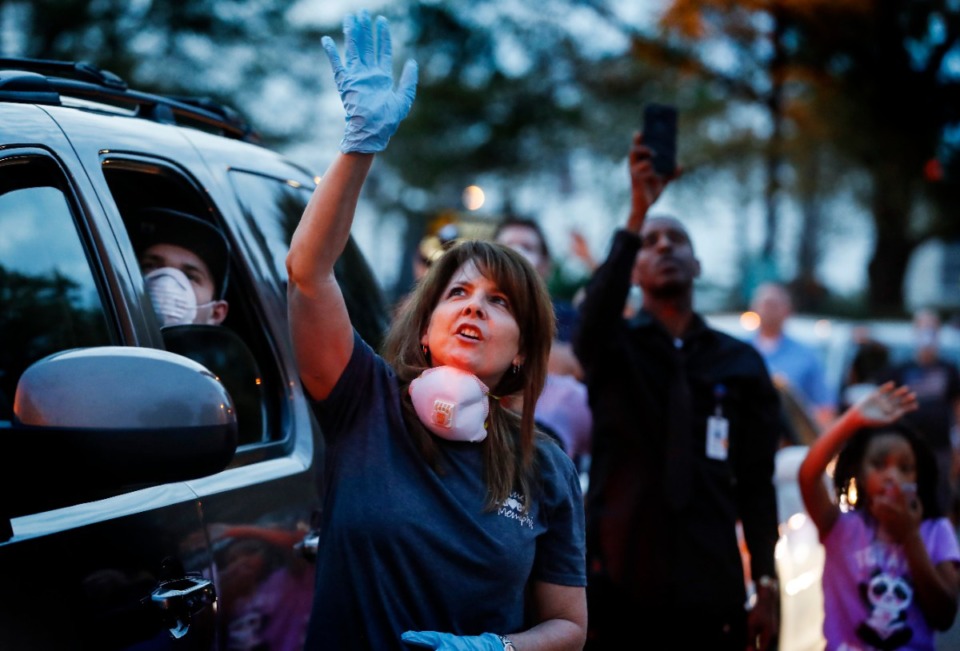 <strong>Event organizer Julie Abell (middle) waves at patient windows while attending a prayer vigil in the St. Francis Hospital-Memphis parking lot on Monday, April 6, 2020.</strong> (Mark Weber/Daily Memphian)