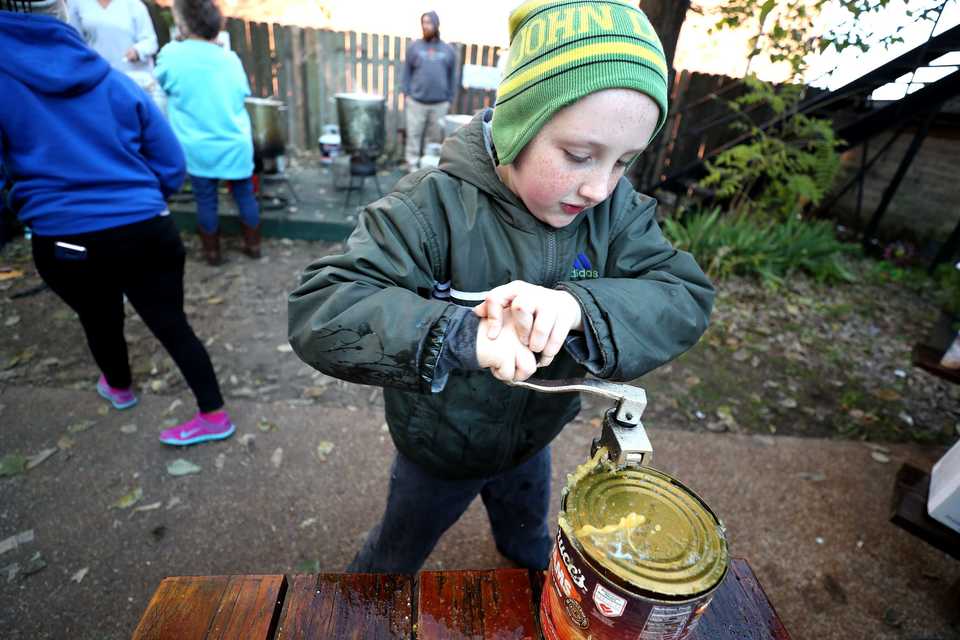<strong>Phoenix Parent, 11, cracks open a can of beans in preparation for the annual free Thanksgiving dinner at Westy's. Westy's has been providing a free Thanksgiving meal for 15 years, and with the help of Operation BBQ Relief and Lindenwood Christian Church they're able to serve hundreds of meals to those in need.</strong> (Houston Cofield/Daily Memphian)