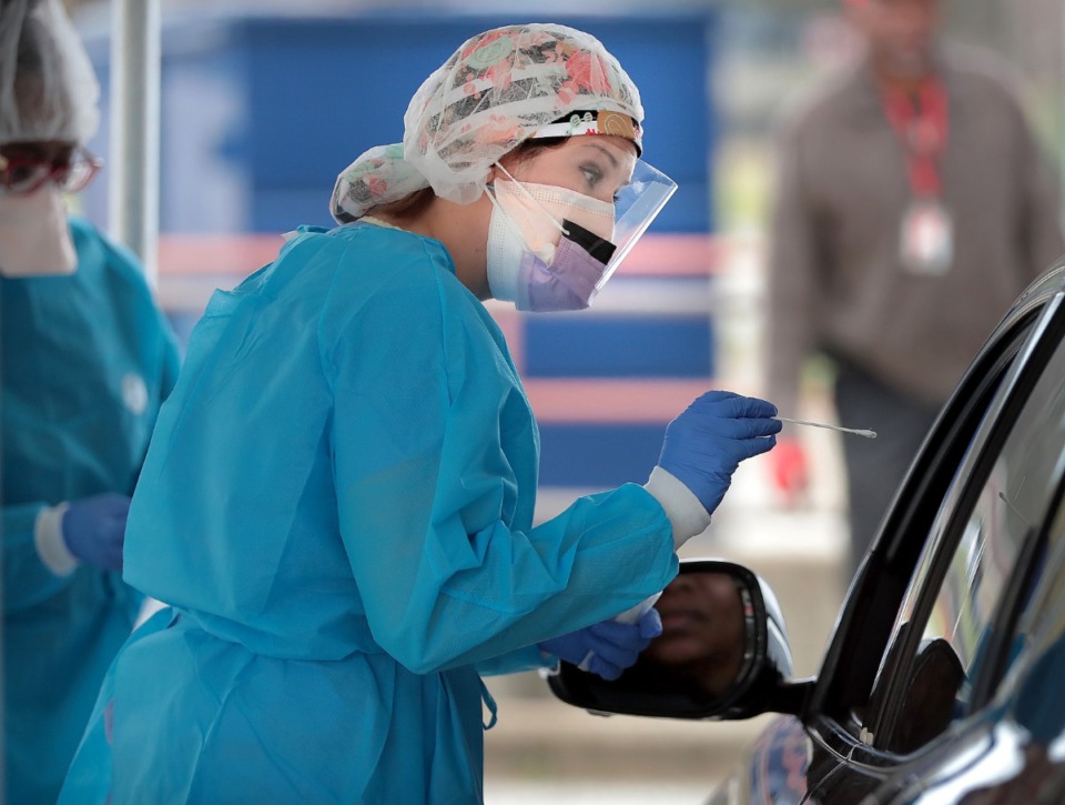 <strong>Blair Longserre, RN, swabs a drive-thru patient as she helps staff from Christ Community Health Services administer COVID-19 tests at a tent behind their South Memphis clinic on March 21, 2020.&nbsp;</strong> (Jim Weber/Daily Memphian file)