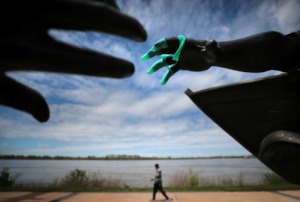 <strong>Davin Roberson passes by the Tom Lee statue with a tattered surgical glove while taking a morning walk through the sparsely populated Tom Lee Park on March 31, 2020.</strong> (Jim Weber/Daily Memphian file)