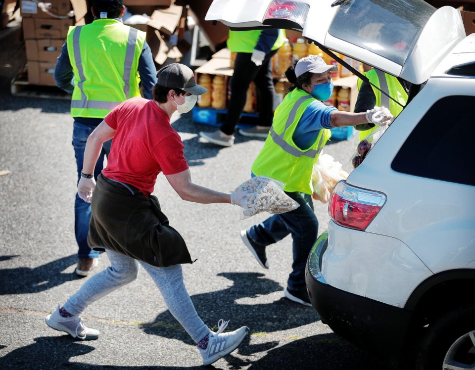 <strong>Some 80 volunteers from Las Americas and Nueva Direccion Church rush to distribute food for 1,000 families on April 10, 2020, from the Mid-South Christian College campus.</strong> (Jim Weber/Daily Memphian)