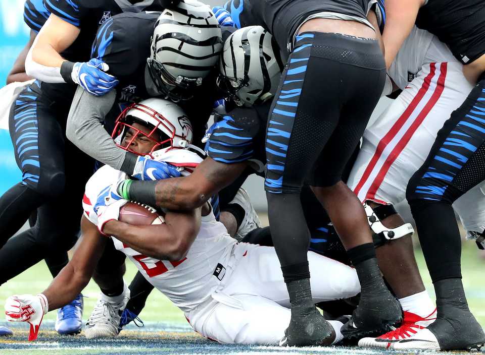 <strong>The University of Memphis defense stops Houston Cougars running back Patrick Carr (21) for a loss on the play&nbsp;The Memphis Tigers defense stops Houston Cougars running back Patrick Carr (21) for a loss on the play&nbsp;<span class="s1">during the matchup Friday, Nov. 23, at Liberty Bowl Memorial Stadium.</span>&nbsp;</strong>(Houston Cofield/Daily Memphian)