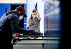 <strong>KIPP Memphis Collegiate High teachers Caitlyn Kennedy (right) and Will Redmond disinfect several hundred laptops on April 3, 2020, for distribution to students, as they continue their education from home. On April 15, Gov. Bill Lee called for schools to shut down for remainder of academic year.</strong> (Mark Weber/Daily Memphian file)