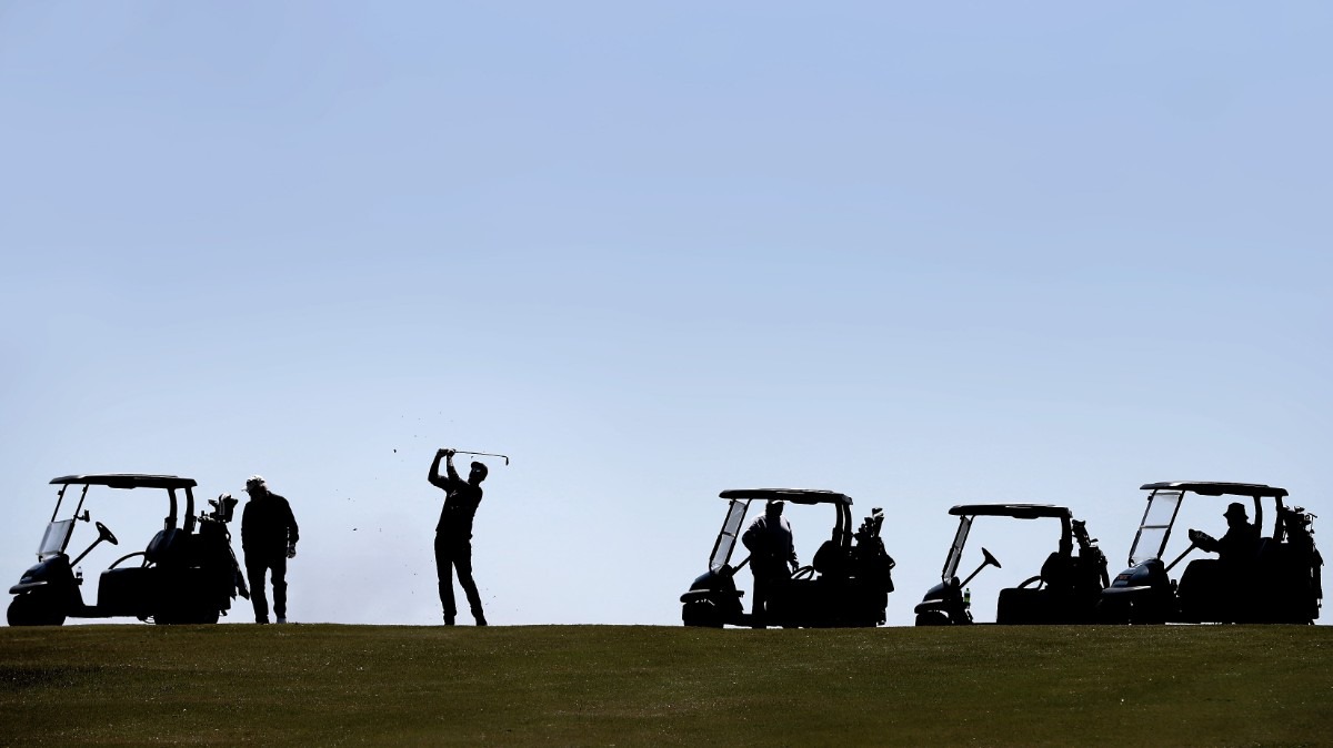 <strong>Michale Kruckman (center) hits from the fairway while playing a game of Texas skins as golfers return to the Links at Whitehaven golf course on April 18, 2020, on a trial basis to test whether golfers would adhere to social distancing requirements during play. Only one person was permitted per cart and golfers were not allowed to handle the flag. (</strong>Jim Weber/Daily Memphian)