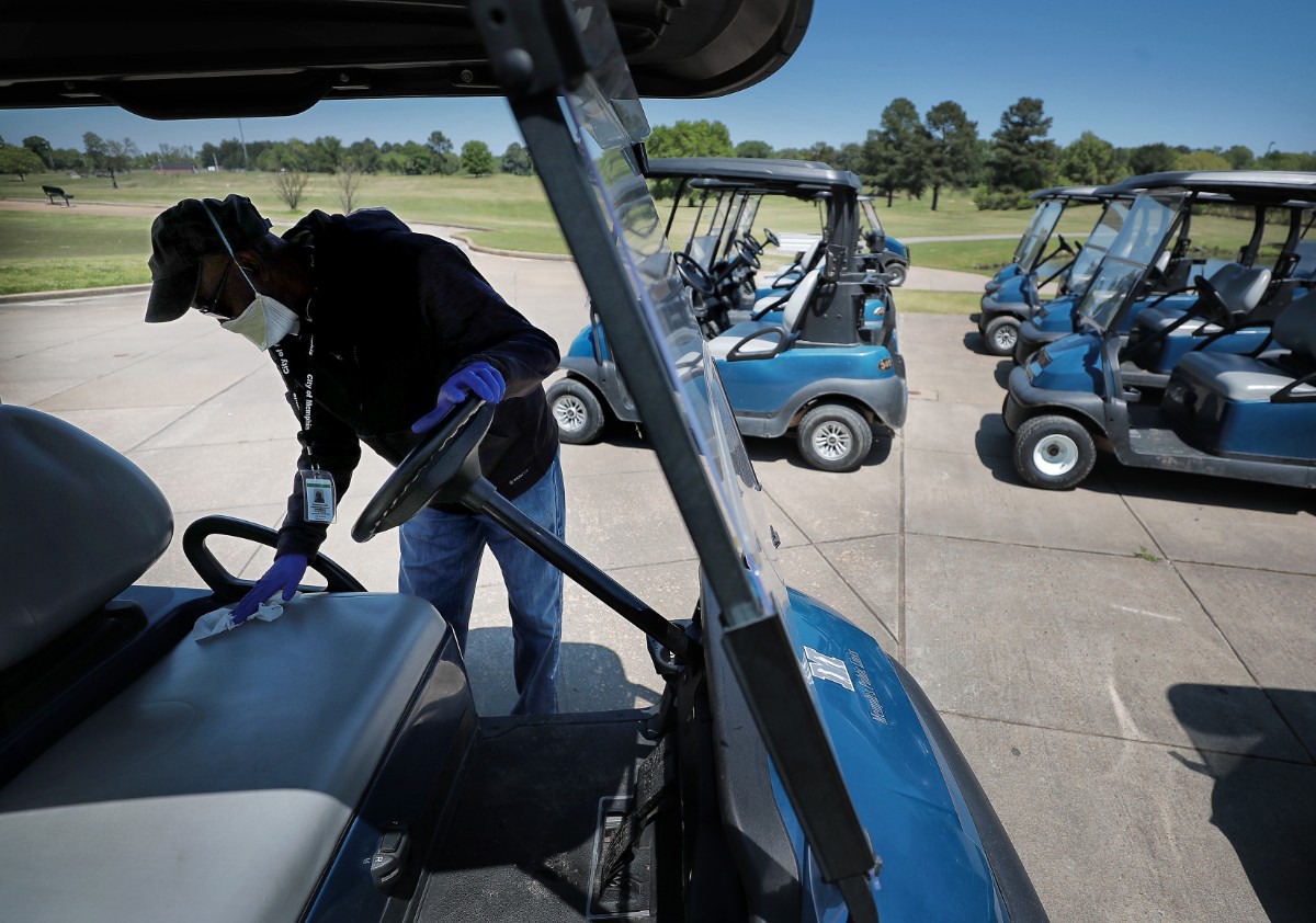 <strong>Clubhouse attendant Thomas Laws disinfects golf carts as golfers return to the Links at Whitehaven golf course on April 18, 2020, on a trial basis to test whether golfers would adhere to social distancing requirements during play. Only one person was permitted per cart and golfers were not allowed to handle the flag.</strong> (Jim Weber/Daily Memphian)