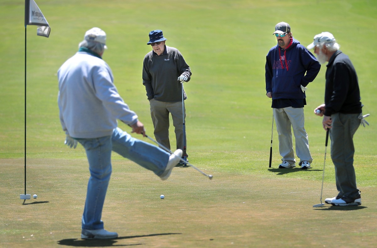 <strong>Don Bumpous (left) reacts to a missed putt while Bill Sheppard, Ray Duncan and Lou Albonetti (right) watch from the edge of the green as golfers return to the Links at Whitehaven golf course on April 18, 2020, on a trial basis to test whether golfers would adhere to social distancing requirements during play. Only one person was permitted per cart and golfers were not allowed to handle the flag.</strong> (Jim Weber/Daily Memphian)