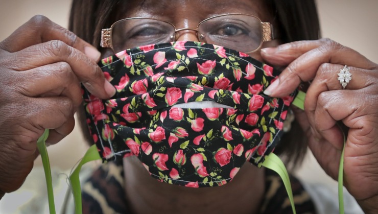 <strong>Corrections program specialist Gloria Phillips shows a finished product as inmates at the Shelby County Correctional Center learn how to make fabric masks on April, 17, 2020, in the midst of the coronavirus pandemic.</strong> (Jim Weber/Daily Memphian)