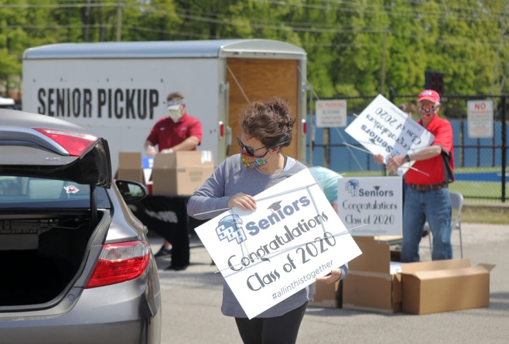 <strong>Amy Lovinelli loads up a yard sign in the trunk of a St. Benedict Academy class of 2020 parent while picking up their child&rsquo;s cap and gown April 17, 2020.</strong> (Patrick Lantrip/Daily Memphian)