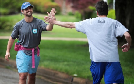 <strong>Nate Franklin gets a high-five from his father-in-law Steve Libby (right) as he starts running again after a short break close to the midway point of his solo marathon in East Memphis on April 25, 2020.</strong> (Jim Weber/Daily Memphian)