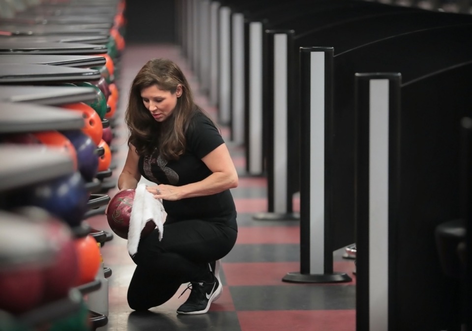 <strong>Andy B's Entertainment &amp; Bowling Center general manager Traci Sanchez disinfects bowling balls on April 24, 2020, as part of a strict cleaning regimen. Sanchez says her staff has been cleaning since they closed, and that they are mostly ready to reopen when official word comes down. They expect big crowds upon reopening and plan to temperature check all patrons.</strong> (Jim Weber/Daily Memphian)
