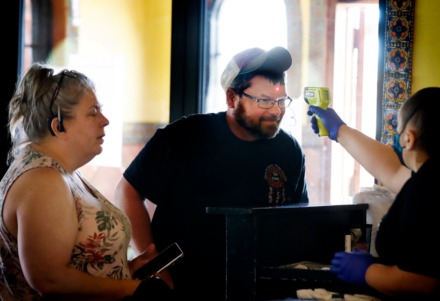 <strong>Travis Wilson (middle) has his temperature taken along with Christy Tillman before enjoying lunch at Margaritas on Monday, April 27, 2020, in Munford.</strong>&nbsp;(Mark Weber/Daily Memphian)