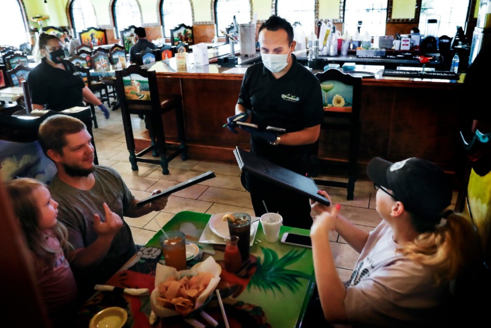 <strong>Margaritas server Saul Ortiz (middle) takes a lunch order from the Wilson family on Monday, April 27, 2020, in Munford.</strong> (Mark Weber/Daily Memphian)